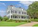 A grand, historic white home with black shutters, a charming porch and manicured front yard at 227 Oak View Way, Summerville, SC 29483