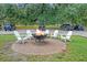 Outdoor brick firepit surrounded by white Adirondack chairs is perfect for entertaining guests at 227 Oak View Way, Summerville, SC 29483