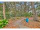 Beautiful backyard with mature trees, stone pathway and blue decorative planter adding to the inviting outdoor space at 26 Edgewater Aly, Isle of Palms, SC 29451