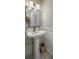 Bathroom with white pedestal sink and basket, a mirror with silver frame, and elegant light fixtures at 26 Edgewater Aly, Isle of Palms, SC 29451