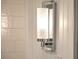 Modern bathroom light fixture with frosted glass and chrome accents against white tiled walls at 26 Edgewater Aly, Isle of Palms, SC 29451