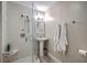 Bright bathroom featuring a glass shower with rainfall head and a pedestal sink with modern fixtures at 26 Edgewater Aly, Isle of Palms, SC 29451