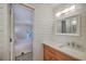 Modern bathroom with wooden vanity, marble countertop, and view of the bedroom through the doorway at 26 Edgewater Aly, Isle of Palms, SC 29451