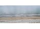 Expansive sandy beach meets gentle waves under an overcast sky, a serene coastal landscape at 26 Edgewater Aly, Isle of Palms, SC 29451