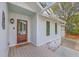 Charming home exterior showcasing a wood front door, covered porch, and manicured landscaping at 26 Edgewater Aly, Isle of Palms, SC 29451