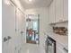 Hallway view into a butler's pantry with a wine refrigerator, sink, and ample cabinet space and a view of the kitchen at 26 Edgewater Aly, Isle of Palms, SC 29451