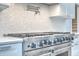 Modern kitchen featuring a stainless steel range with a mosaic tile backsplash and pot filler faucet at 26 Edgewater Aly, Isle of Palms, SC 29451