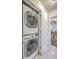 Laundry closet featuring stacked washer and dryer with view into the dining room at 26 Edgewater Aly, Isle of Palms, SC 29451