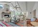 Cozy living room with vaulted ceilings, a ceiling fan, exposed beams and a fireplace, next to the modern kitchen at 26 Edgewater Aly, Isle of Palms, SC 29451
