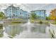A tranquil pond with a fountain in front of multi-story condos with manicured landscaping at 26 Edgewater Aly, Isle of Palms, SC 29451
