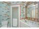 Charming bathroom with unique fish wallpaper, glass shower, and elegant fixtures at 2629 Goldbug Ave, Sullivans Island, SC 29482
