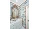 Stylish powder room with fish-themed wallpaper, a unique mirror, and a marble countertop at 2629 Goldbug Ave, Sullivans Island, SC 29482