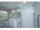 Bathroom with a glass-enclosed shower, marble vanity, and a large window providing natural light at 2629 Goldbug Ave, Sullivans Island, SC 29482