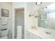 Well-lit bathroom with a glass-enclosed shower, white vanity, and stylish wall decor at 2629 Goldbug Ave, Sullivans Island, SC 29482
