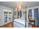 Bedroom with a canopy bed, a stylish chandelier, and access to a private outdoor deck at 2629 Goldbug Ave, Sullivans Island, SC 29482