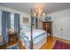 Spacious bedroom featuring a four-poster bed, chandelier, and blue patterned bedding at 2629 Goldbug Ave, Sullivans Island, SC 29482