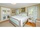 Comfortable main bedroom with a well-lit space, a door that leads to the backyard, wood floors, and curtains at 2629 Goldbug Ave, Sullivans Island, SC 29482