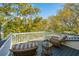 Inviting deck area with wicker furniture perfect for enjoying the lush backyard views at 2629 Goldbug Ave, Sullivans Island, SC 29482
