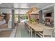 Stylish dining area with a wooden table, modern pendant lights, and an open view to the pool and outdoor kitchen at 2629 Goldbug Ave, Sullivans Island, SC 29482