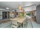 Elegant dining area with a long wooden table, stylish pendant lights, and access to the outdoor pool area at 2629 Goldbug Ave, Sullivans Island, SC 29482