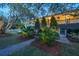 Lovely home exterior showcasing a covered porch, lush landscaping, and a welcoming entrance with mature trees at 2629 Goldbug Ave, Sullivans Island, SC 29482