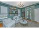 Comfortable living room with a door that leads to the backyard, custom bookshelves, and decor at 2629 Goldbug Ave, Sullivans Island, SC 29482