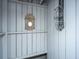Charming outdoor shower with gray wood planking, ornate mirror, and shelving for bath supplies at 2629 Goldbug Ave, Sullivans Island, SC 29482