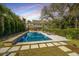 A backyard pool with stone pavers, lounge chairs, and lush landscaping at 2629 Goldbug Ave, Sullivans Island, SC 29482
