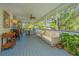 Relaxing screened porch featuring wicker seating, a dining table, and views of the mature trees at 2629 Goldbug Ave, Sullivans Island, SC 29482