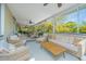 Spacious screened porch featuring ample seating, a wood coffee table, and views of lush greenery at 2629 Goldbug Ave, Sullivans Island, SC 29482
