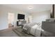 A staged bedroom showcases a stylish bed, modern dresser with a TV, and an ensuite bathroom entrance at 265 Lucca Dr, Summerville, SC 29486