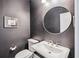 Powder room featuring a pedestal sink, round mirror, and a toilet at 2743 Calico Bass Ln, Johns Island, SC 29455