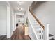 The hallway has wood floors and leads to a carpeted living room and has a staircase with a wooden handrail at 2743 Calico Bass Ln, Johns Island, SC 29455