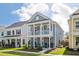 Beautiful two-story home with a welcoming double porch and manicured lawn on a sunny day at 2743 Calico Bass Ln, Johns Island, SC 29455