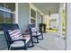 Inviting front porch features cozy rocking chairs with stylish cushions, providing a relaxing outdoor space at 2743 Calico Bass Ln, Johns Island, SC 29455