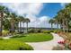 Scenic lake view framed by palm trees, manicured landscaping, and a charming walkway in a serene community at 2743 Calico Bass Ln, Johns Island, SC 29455
