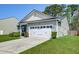 Two-car garage with white door, concrete driveway, small landscaping in a well-maintained lawn at 2914 Glenarden Dr, Charleston, SC 29414