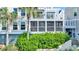 Exterior of the home showcases a screened porch and balcony, surrounded by lush greenery and landscaping at 2933 Atrium Villa Dr # 33, Seabrook Island, SC 29455