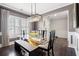 Dining room with glass table, modern chandelier, wainscotting, and natural light from plantation shutters at 301 Dunlin Dr, Summerville, SC 29486