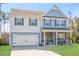 Charming two-story home with a two-car garage, covered porch, and well-manicured lawn at 301 Dunlin Dr, Summerville, SC 29486