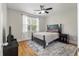 This cozy bedroom has a ceiling fan, a large window, a bed with a dark wood frame, and decorative elements at 3023 Macbeth Creek Dr, Charleston, SC 29414