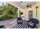 Cozy front porch with a black and white rug, comfortable seating, and hanging ferns for a relaxing outdoor space at 3023 Macbeth Creek Dr, Charleston, SC 29414