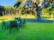 Spacious backyard featuring an outdoor dining area, Adirondack chairs, mature trees, and a serene pond view at 3025 Dewitt Ct, Hollywood, SC 29449