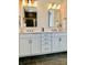 Bathroom with double sink vanity, black floors, white cabinets, and modern fixtures with excellent lighting at 3025 Dewitt Ct, Hollywood, SC 29449