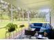 Cozy screened porch with an L-shaped couch, glass table, potted plants and a view of the lush green lawn at 3025 Dewitt Ct, Hollywood, SC 29449