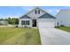 Charming single-Gathering home with blue and gray siding, a manicured lawn, and an attached garage at 309 Torslanda Ln, Summerville, SC 29486