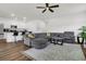 Open-concept living area flows from a kitchen, offering a plush gray sectional sofa and hardwood floors at 309 Torslanda Ln, Summerville, SC 29486