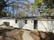 Cozy home exterior with a pathway leading to the entrance, set amidst a backdrop of lush trees at 334 E Poplar Branch Dr, Moncks Corner, SC 29461