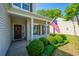Cozy front porch featuring an American flag, lush greenery, and a welcoming entryway at 3363 Kinross Ct, Summerville, SC 29485