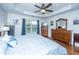 Bright main bedroom with a tray ceiling, ceiling fan, wooden dresser and light blue bedspread at 3363 Kinross Ct, Summerville, SC 29485